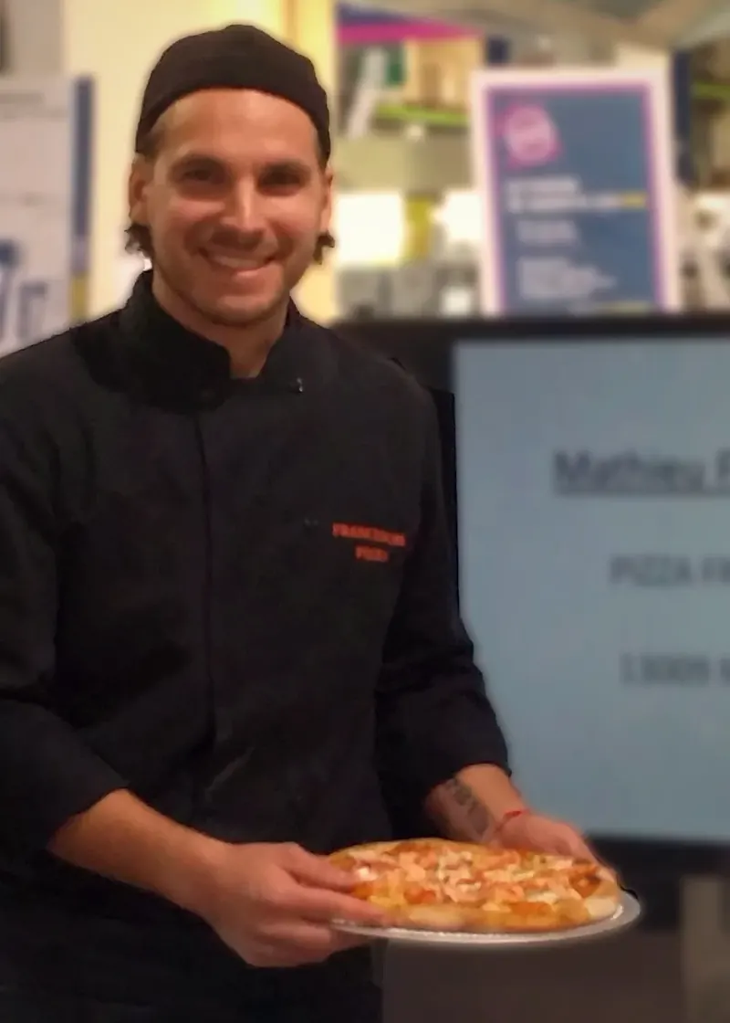 Mathieu Franceschi, fondateur de Franceschi Pizza, une pizza à la main